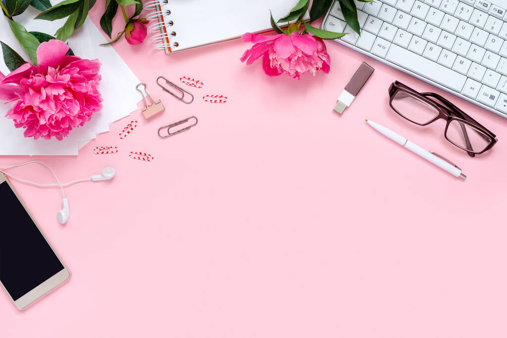 Laptop, accessories and bouquet of beautiful peonies with glasses and headphones on pink background. Flat lay of working place.  - Photo, Image