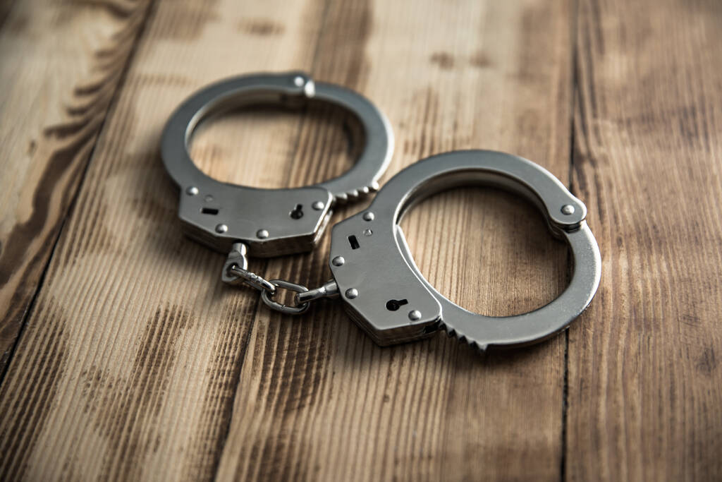 наручники на деревянном столе спинка
 - Фото, изображение