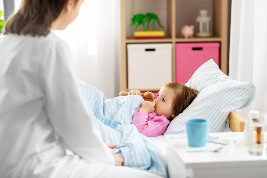 doctor and sick little girl in bed at home - Photo, Image