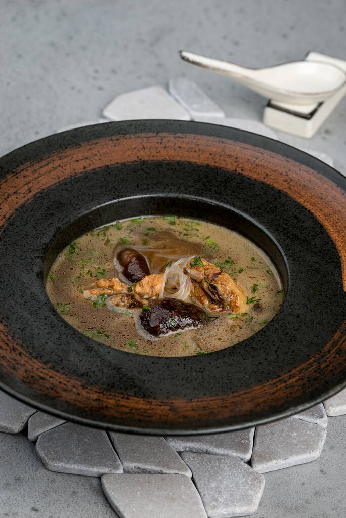 Sopa de champiñones en un plato marrón profundo
 - Foto, Imagen