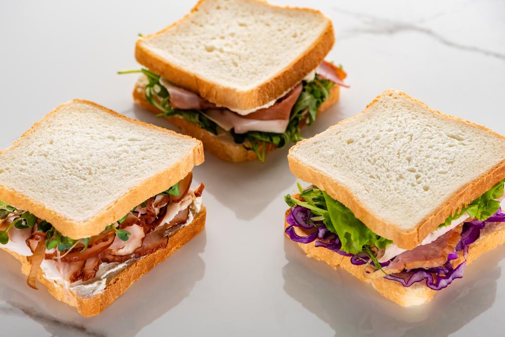 свіжі зелені бутерброди з м'ясом на мармуровій білій поверхні
 - Фото, зображення