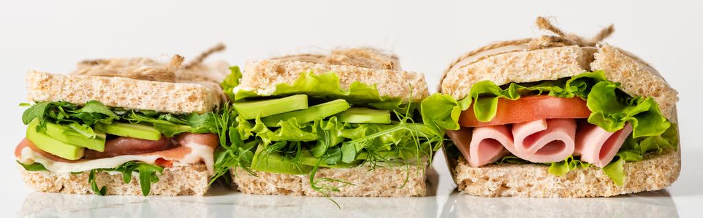 sandwichs verts frais avec avocat et viande sur surface blanche, panoramique - Photo, image