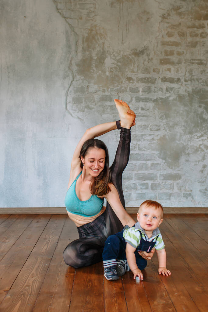 Yoga-Mädchen macht neben ihrem kleinen Sohn eine Übung - Foto, Bild