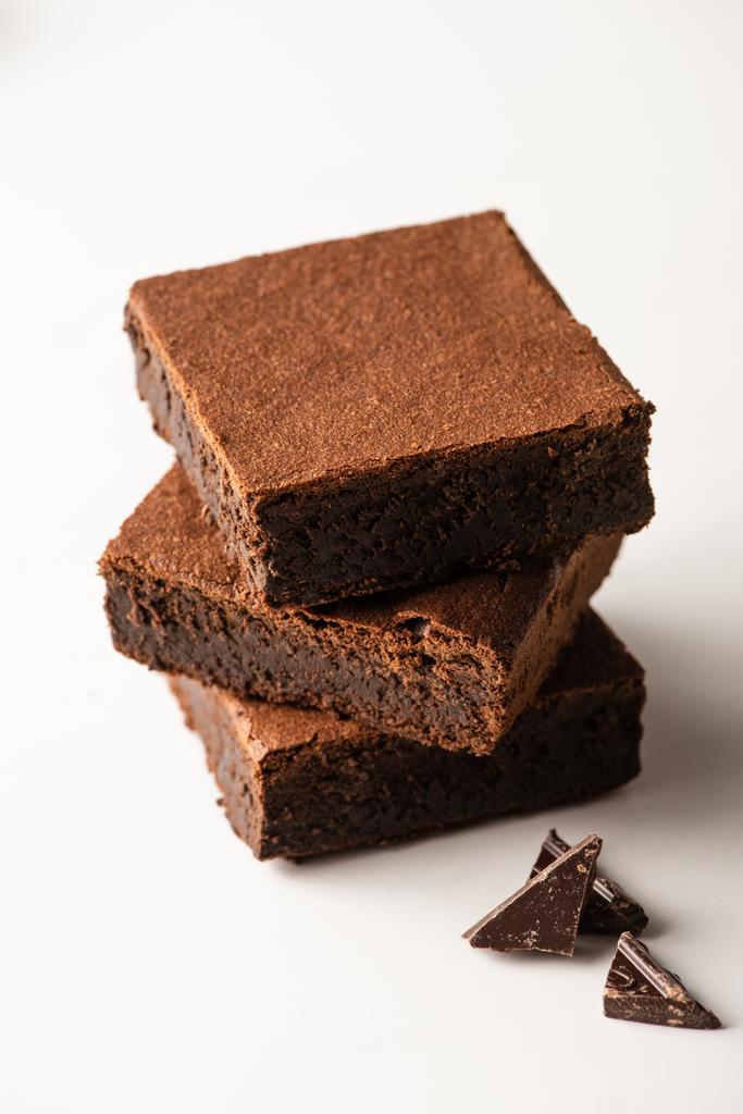 Beyaz arkaplanda siyah çikolata olan lezzetli browni parçaları. - Fotoğraf, Görsel