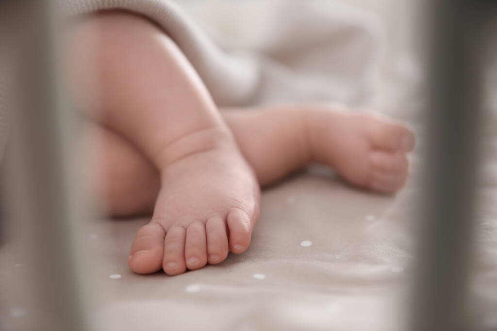 Lindo bebé tendido en la cuna, primer plano de los pies. Hora de dormir
 - Foto, Imagen