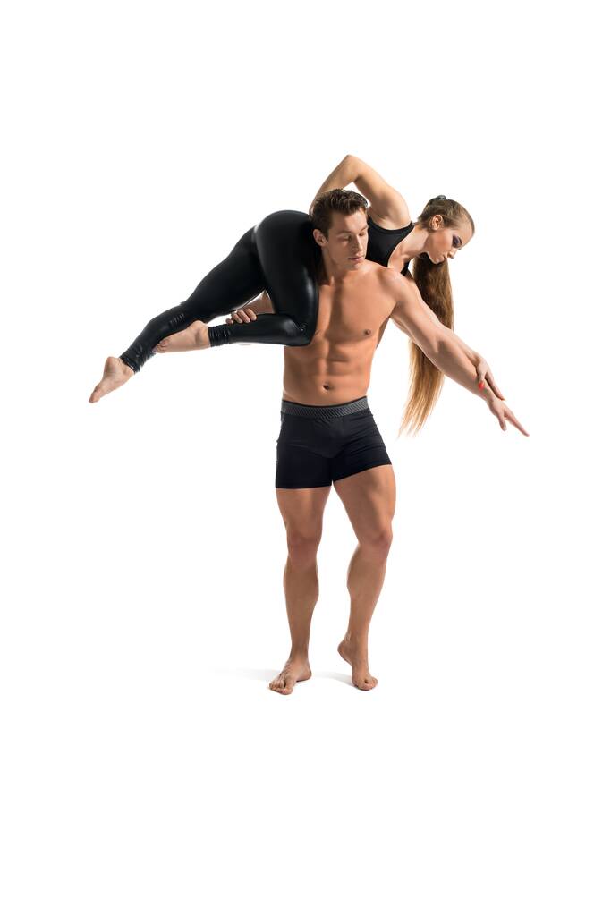 Young couple in spotswear doing acrobatics isolated shot - Photo, Image