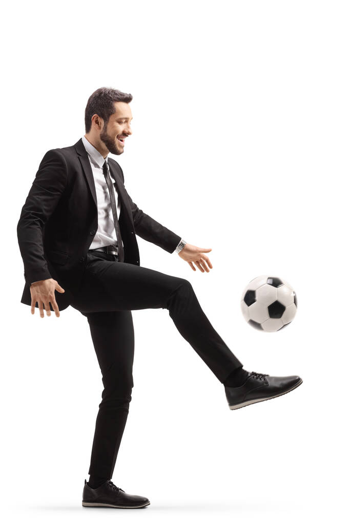 Perfil de comprimento total tiro de um homem de negócios jogando com uma bola de futebol isolado no fundo branco
 - Foto, Imagem