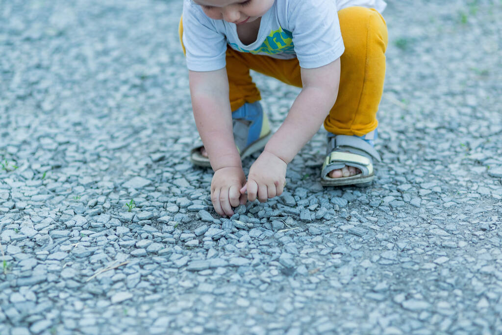 Mains d'un petit garçon plein de petites pierres
 - Photo, image