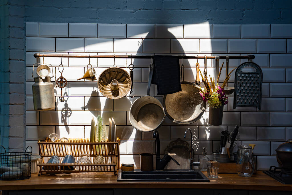 старинные кухонные принадлежности на стене над раковиной. ретро кухонные принадлежности
. - Фото, изображение