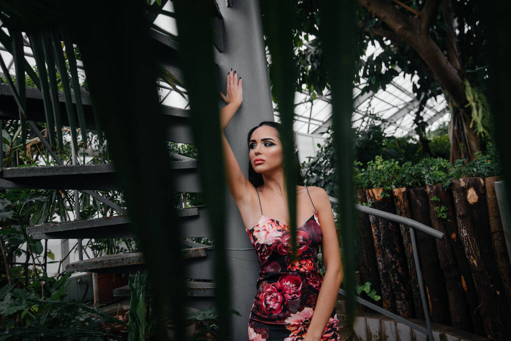 Mladá krásná bruneta pózuje u točitého schodiště v botanické zahradě mezi hustými houštinami tropického lesa. Lázně - Fotografie, Obrázek