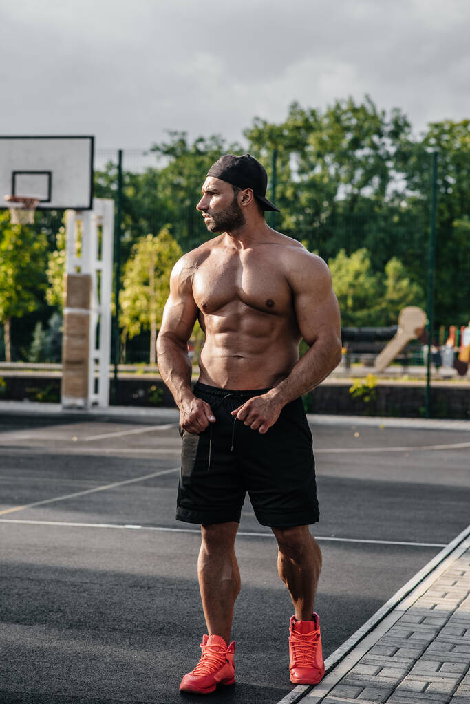 Esportista de fitness sexy posando em um campo de esportes topless. Fitness, musculação, estilo de vida saudável - Foto, Imagem