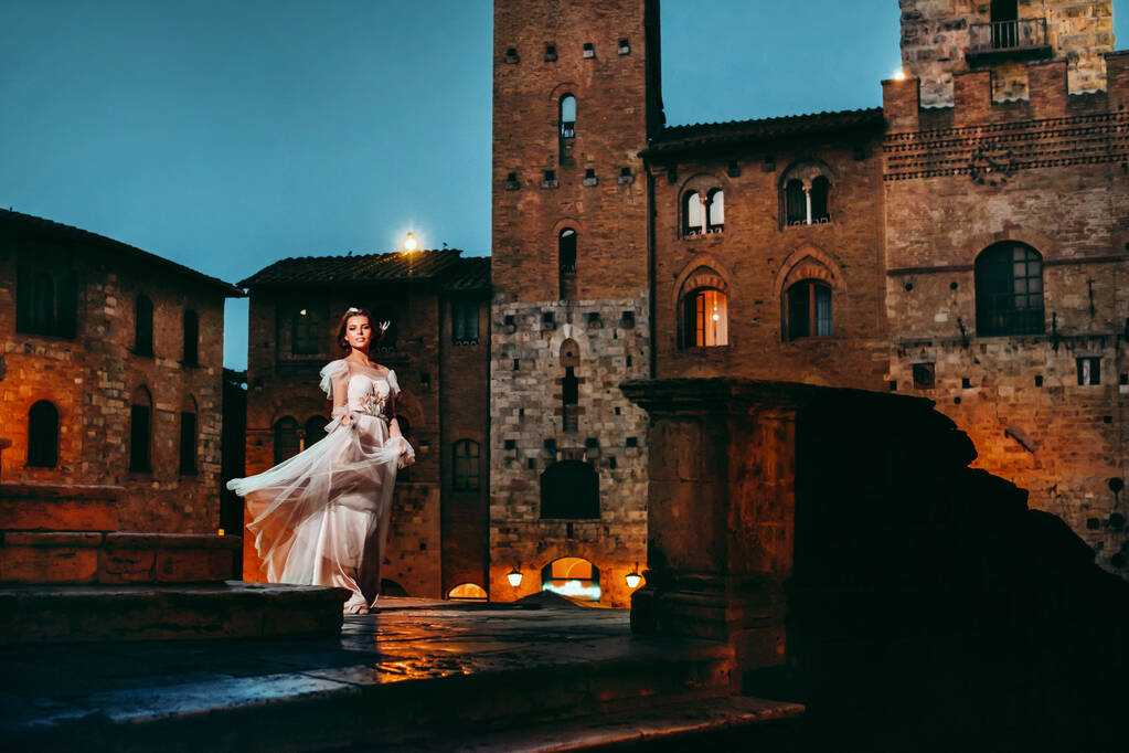 Наречена в білій сукні в старому місті Сан-Джиміньяно. Дівчина ходить по місту на італ. Тоскана - Фото, зображення