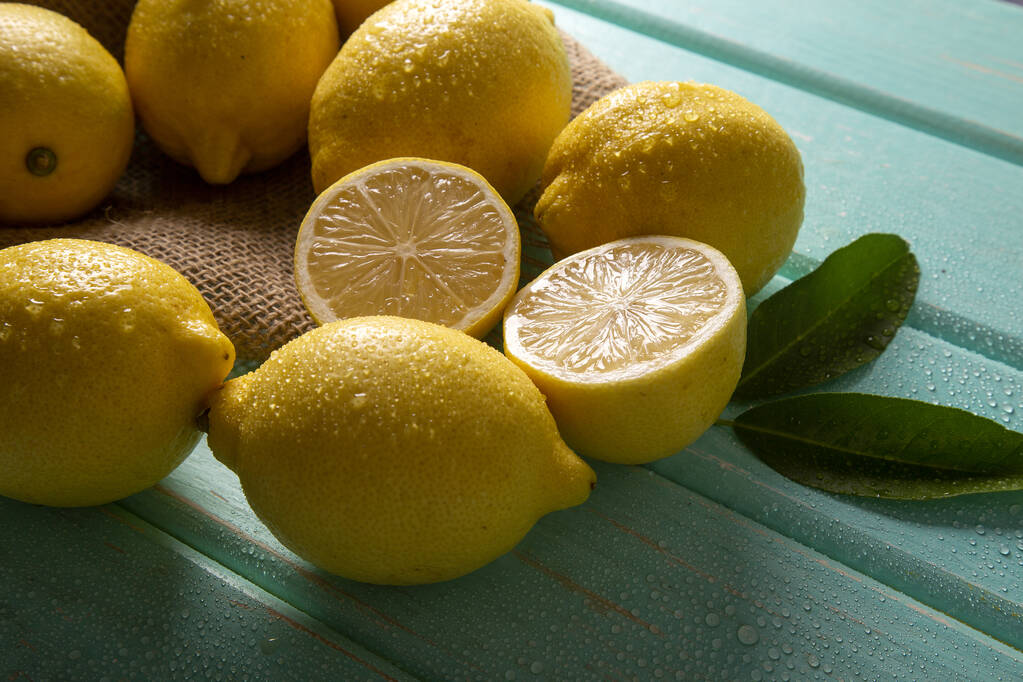 Žluté citrony na zeleném dřevěném pozadí. - Fotografie, Obrázek