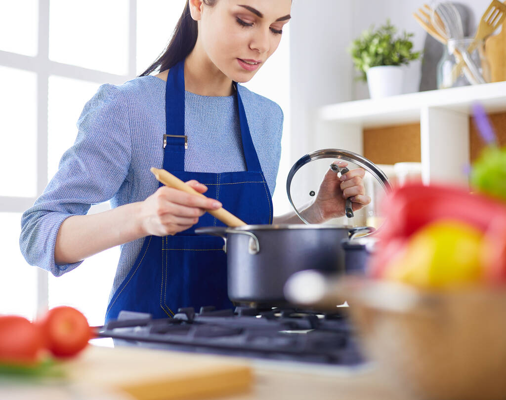 Кулинарная женщина на кухне с деревянной ложкой - Фото, изображение