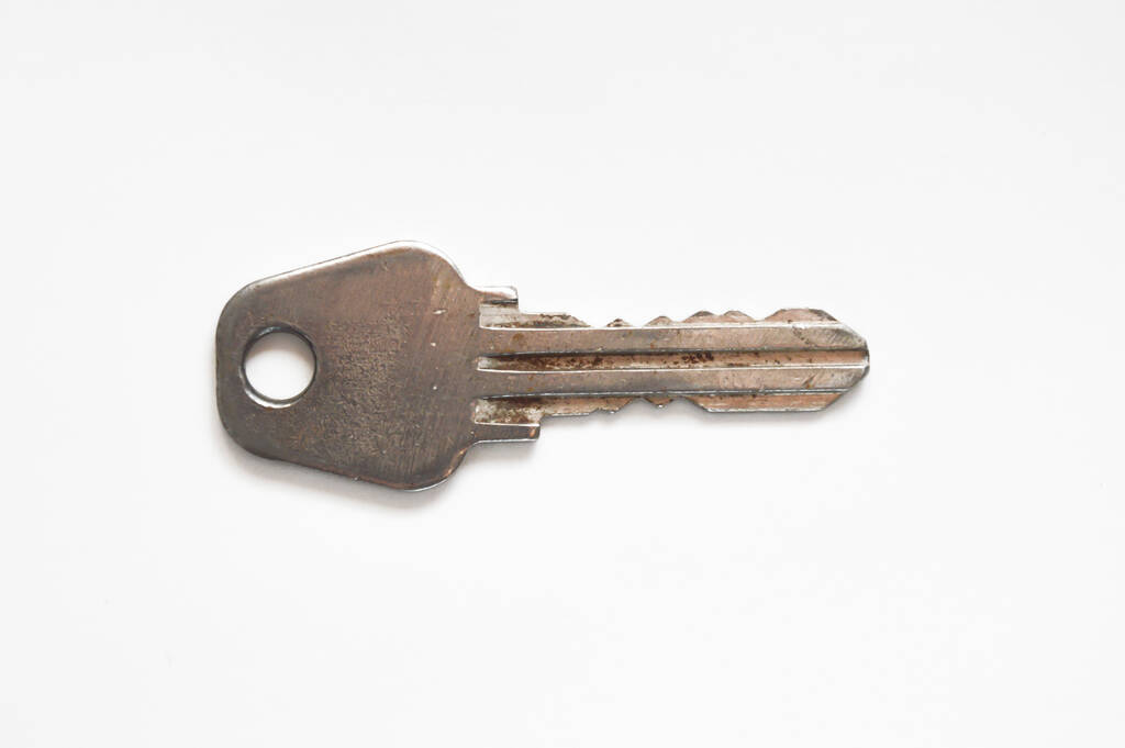 la llave de la puerta principal. llave de metal sobre un fondo blanco
. - Foto, imagen