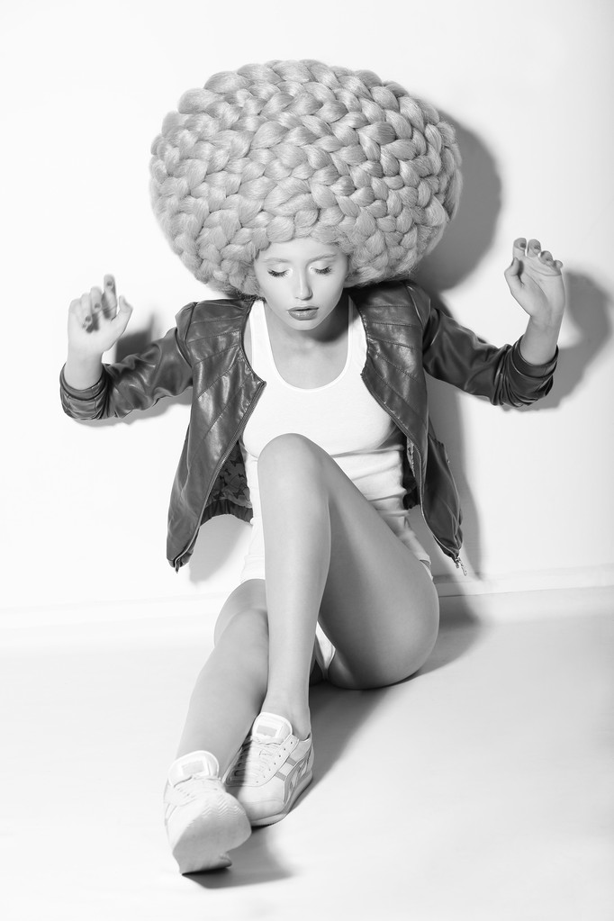 kreatywność. Modna kobieta w ogromna wyobraźnia peruce, siedząc na podłodze - Zdjęcie, obraz