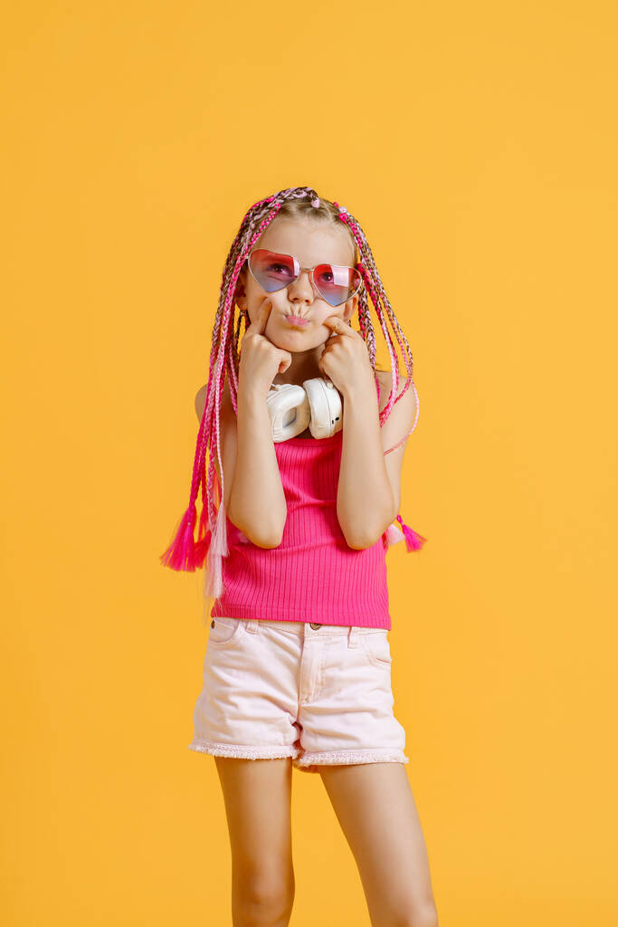 Божевільна виразна модна ді-джея дівчина в яскравому одязі, навушниках і яскравих фонових замках. Дискотека, вечірка
 - Фото, зображення