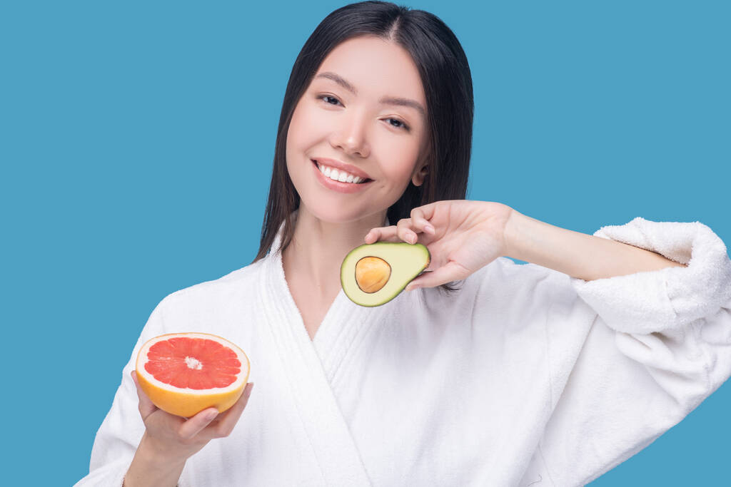 Lächelnde Frau mit Avocado und Grapefruit - Foto, Bild