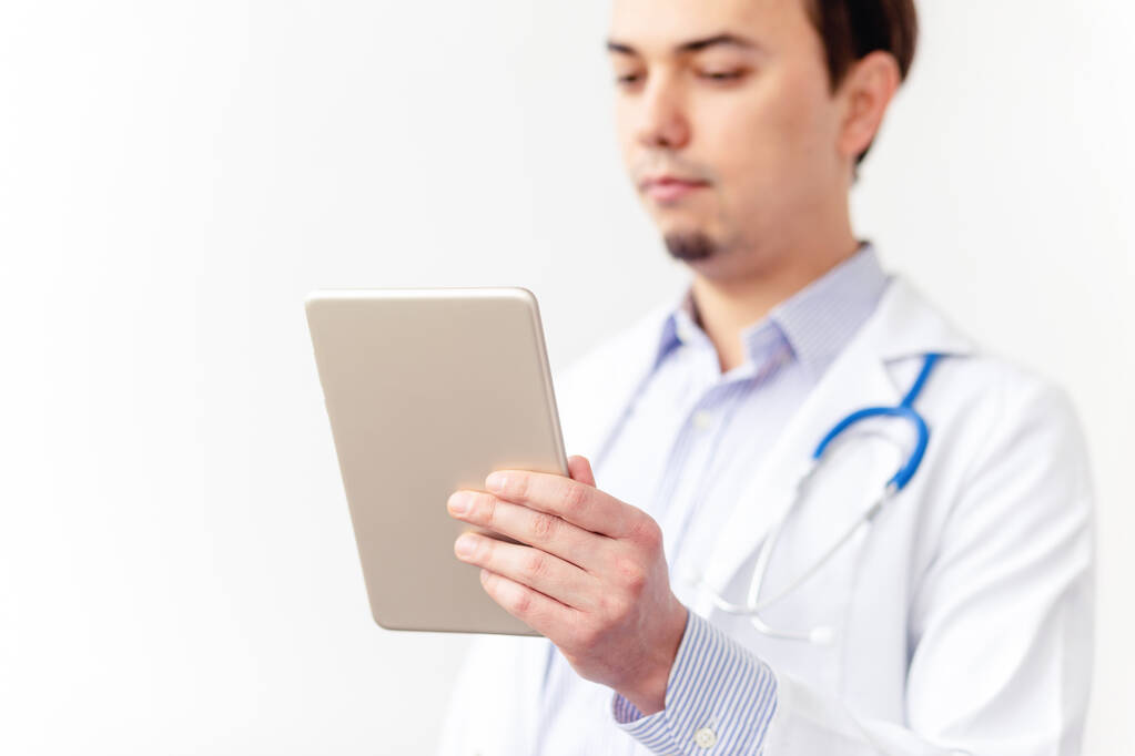 ドクター・オンライン。男性医師は白い背景にタブレットを使用して患者とビデオ通話を話して動作します。タブレットを中心に. - 写真・画像