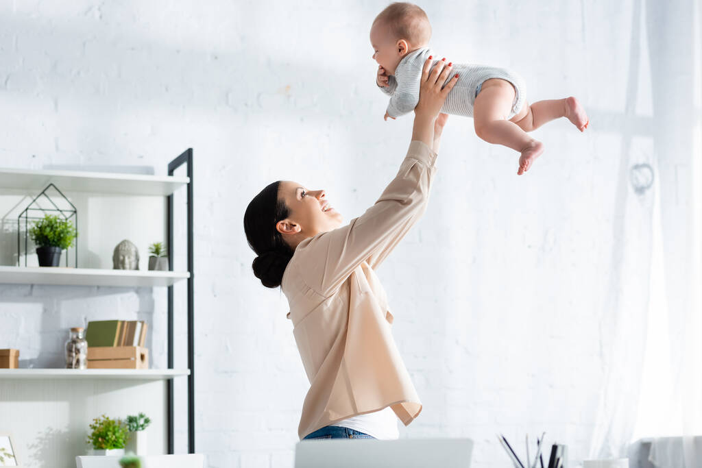 boldog anya gazdaság karok aranyos csecsemő fia baby romper  - Fotó, kép