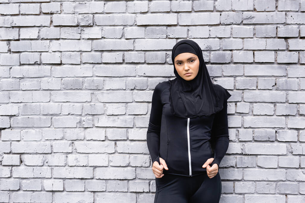 giovane donna musulmana in hijab in piedi vicino al muro di mattoni  - Foto, immagini