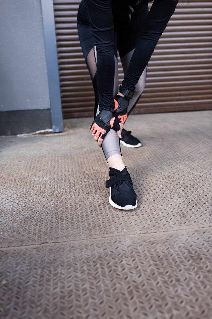 cropped view of young sportswoman touching leggings  - Photo, Image