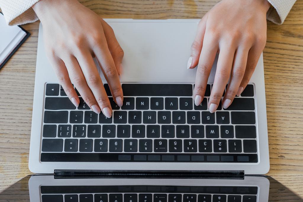 オフィスのノートパソコンのキーボードで入力する女性のトップビュー - 写真・画像