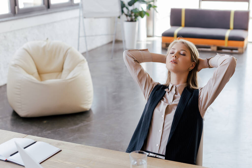 businesswoman with closed eyes relaxing on chair in office - Photo, Image