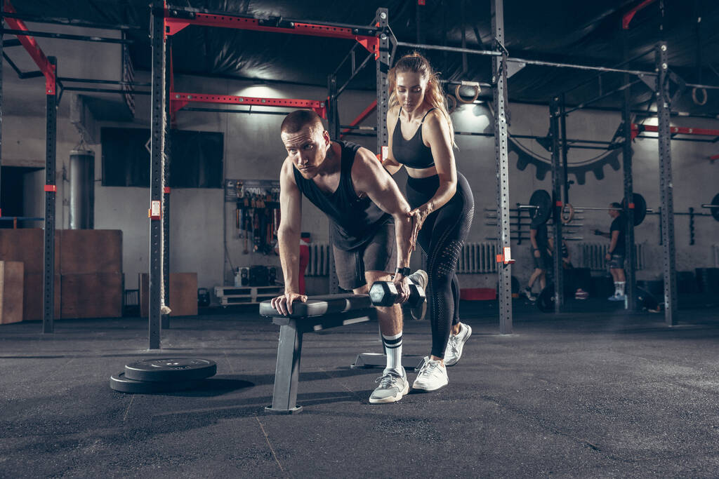 Belle formation de jeune couple sportif, séance d'entraînement en salle de gym ensemble - Photo, image