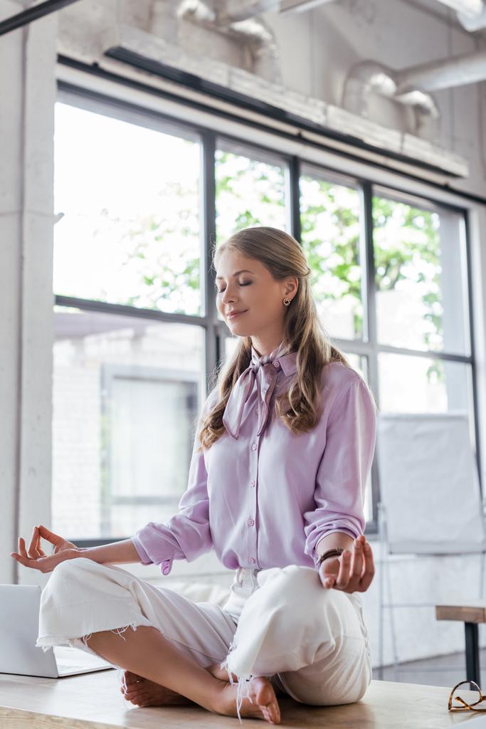 cheerful businesswoman with closed eyes meditating in office - Photo, Image