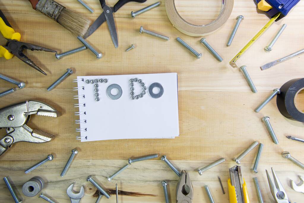 Vysokoúhlý snímek fráze "dělat" ze šroubů na prázdném notebooku na dřevěném povrchu pro plánování práce - Fotografie, Obrázek