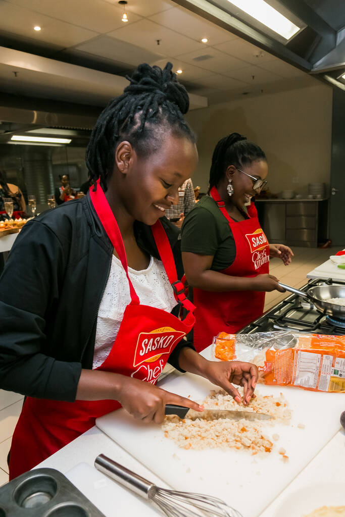 南アフリカのヨハネスブルグ – 2017年10月5日:料理教室で料理と焼き方を学ぶ若いアフリカの女性 - 写真・画像