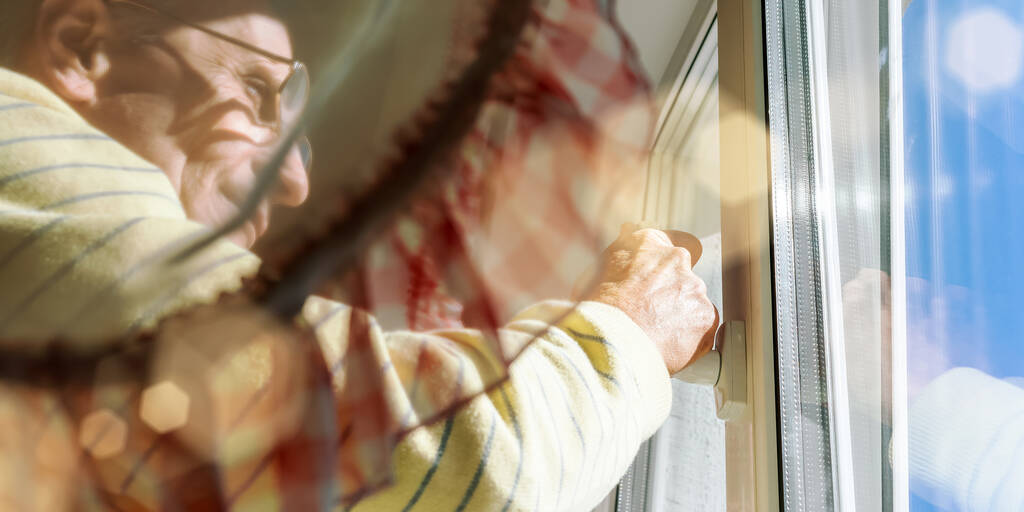 hombre anciano en gafas sostiene la mano en manija de ventana de plástico
 - Foto, imagen