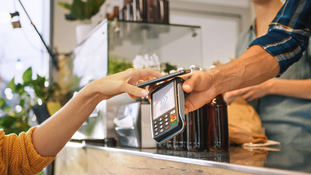 Junge Frau nutzt kontaktlose NFC-Payment-App auf ihrem Smartphone, um Gourme Street Food zu bezahlen. Umweltfreundliche glutenfreie Lebensmittel Gericht verkauft moderne Fusionsküche - Foto, Bild