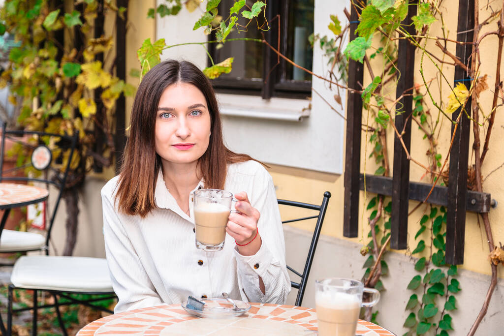 Lächelndes junges Mädchen hält Tasse Kaffee in der Hand - Foto, Bild