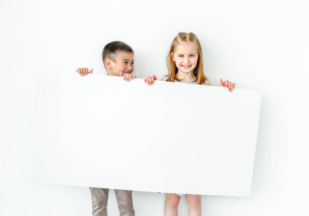 Bambini felici in possesso di grande manifesto vuoto - Foto, immagini