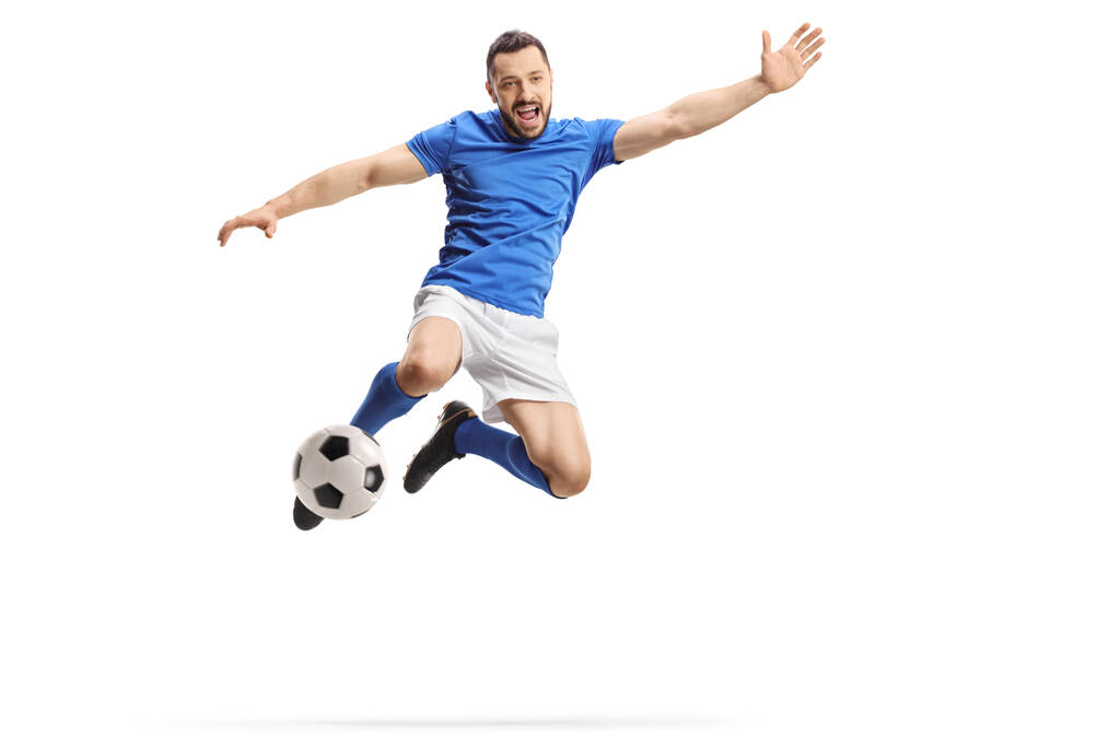 Futbolista saltando y pateando una pelota aislada sobre fondo blanco
 - Foto, imagen