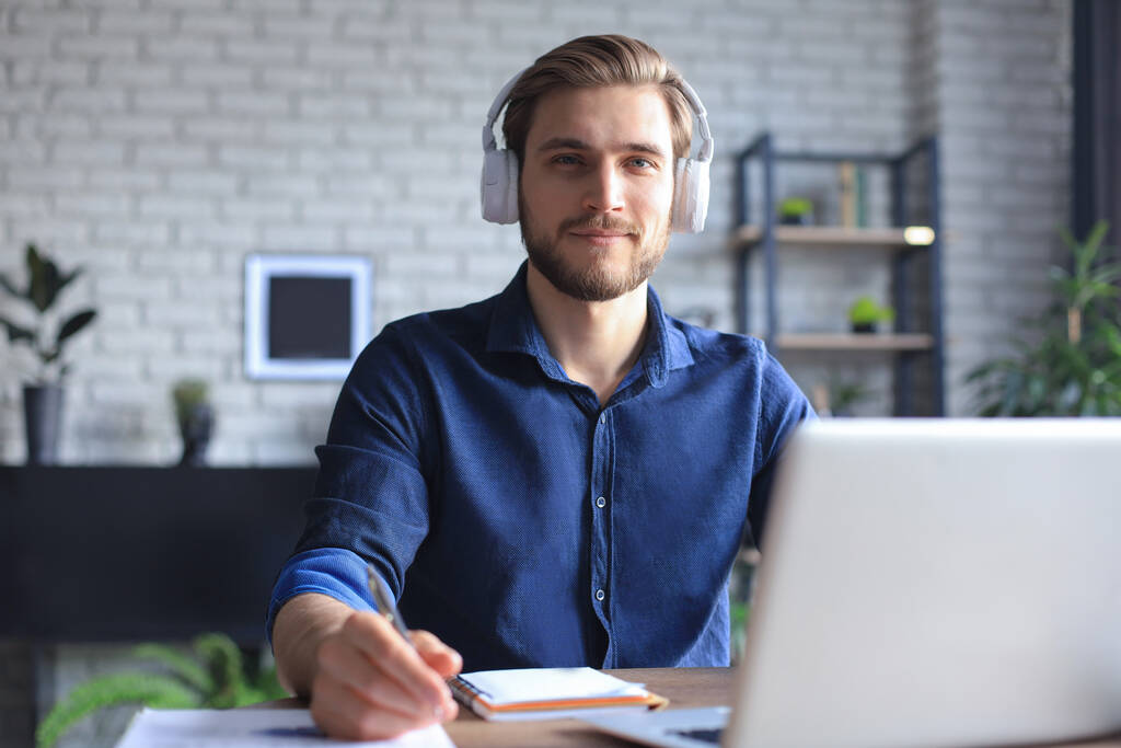 Itsevarma mies käyttää kuulokkeita puhuminen ja katsella liiketoiminnan webinar koulutus, kuuntelee luento - Valokuva, kuva