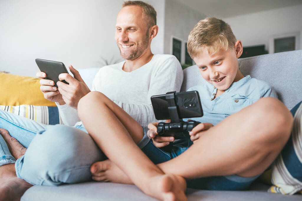 Padre e figlio, giocatori PC, con entusiasmo giocando con i dispositivi elettronici: tablet e gamepad - Foto, immagini
