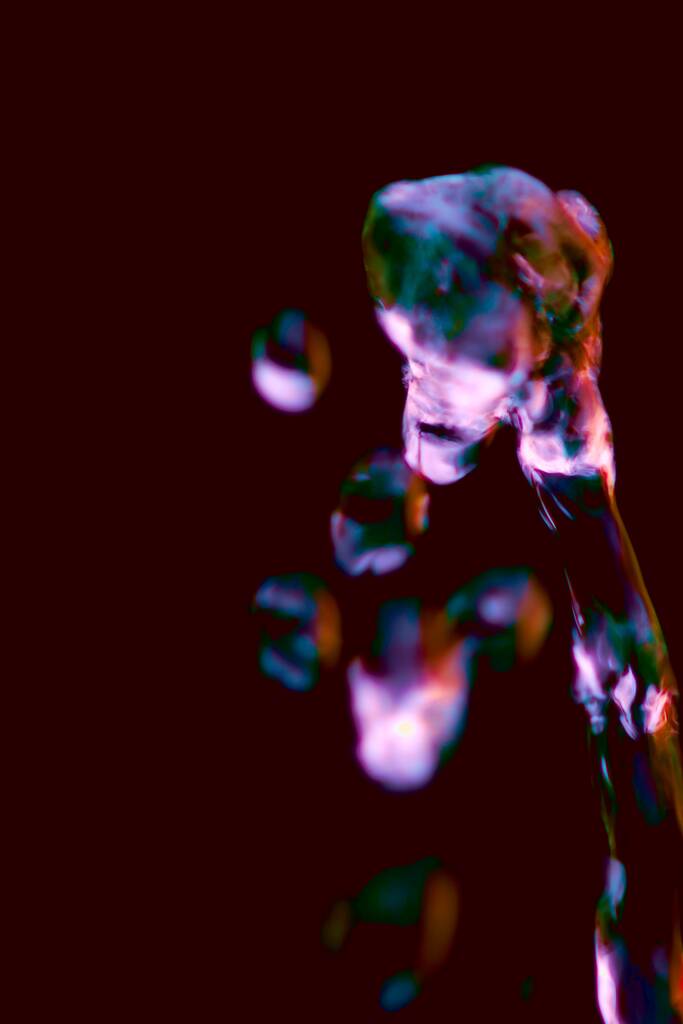 Um tiro vertical de formações gelatinosas em um fundo escuro
 - Foto, Imagem