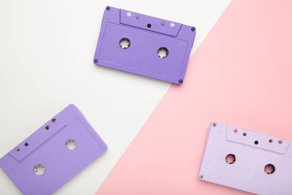Anciennes cassettes colorées sur fond rose et blanc. Jour de musique, vue du dessus - Photo, image