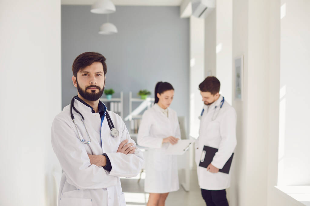 Um grupo de médicos olha para uma foto de raio-X em pé em uma janela em um hospital
. - Foto, Imagem
