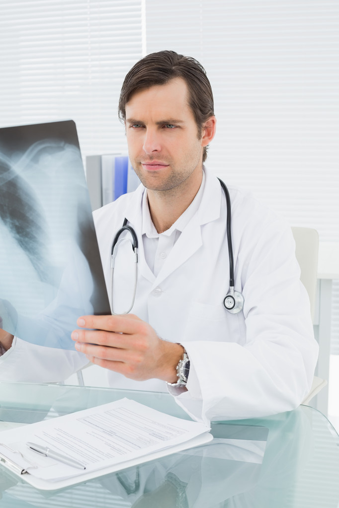 Lääkäri katselee röntgenkuvaa keuhkoista lääketieteellisessä toimistossa
 - Valokuva, kuva