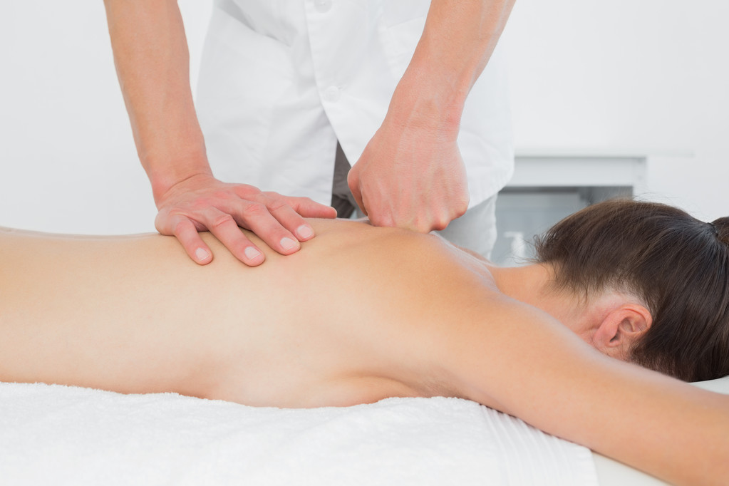 Крупним планом фізіотерапевт масажує спину жінки
 - Фото, зображення