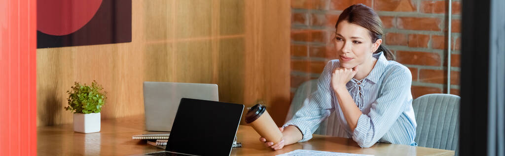 панорамная концепция предпринимательницы, держащей бумажный стаканчик возле ноутбуков
  - Фото, изображение