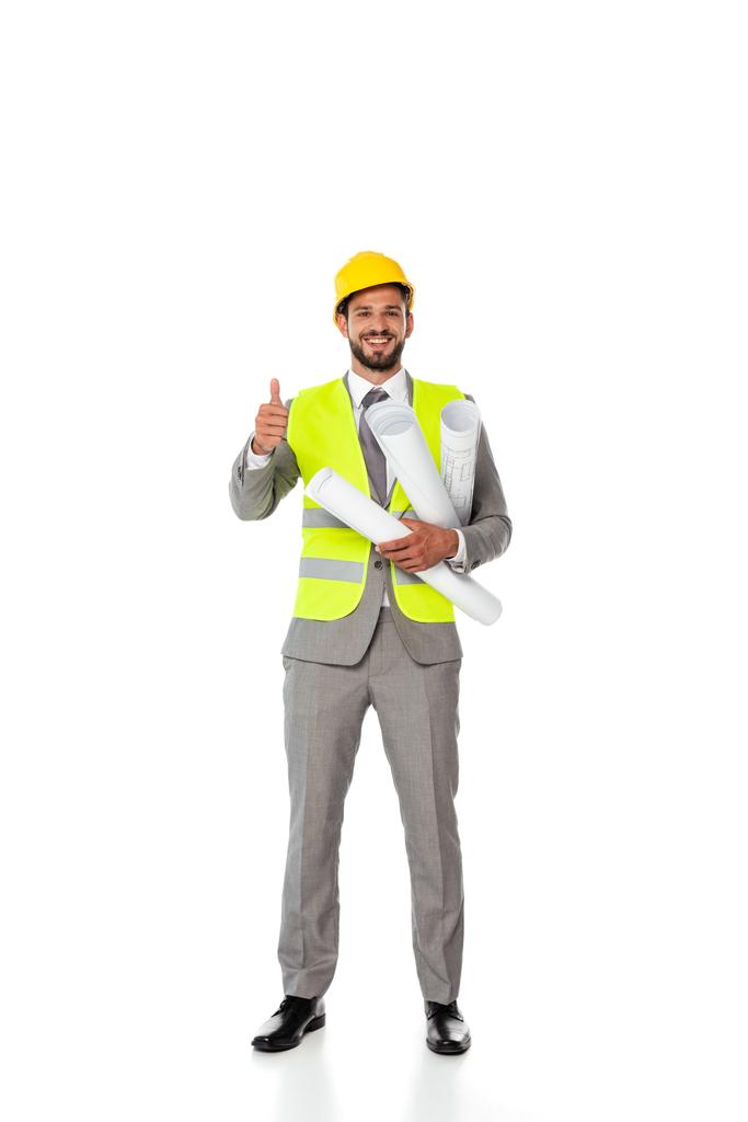 Usmívající se inženýr zobrazující jako gesto a držící plány na bílém pozadí - Fotografie, Obrázek