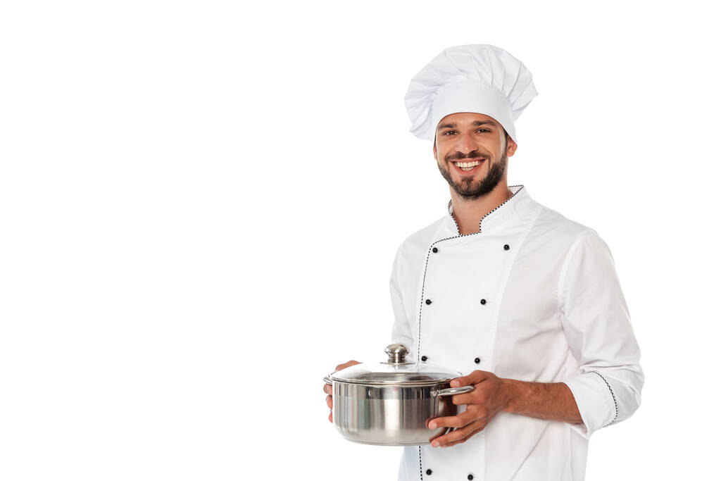Όμορφος σεφ χαμογελά στην κάμερα, ενώ κρατώντας τηγάνι απομονώνονται σε λευκό - Φωτογραφία, εικόνα