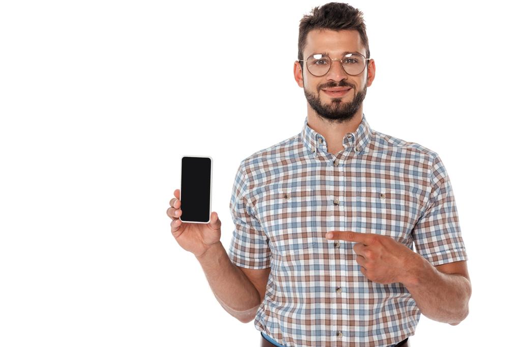 Positieve nerd wijzend met vinger naar smartphone met blanco scherm geïsoleerd op wit - Foto, afbeelding