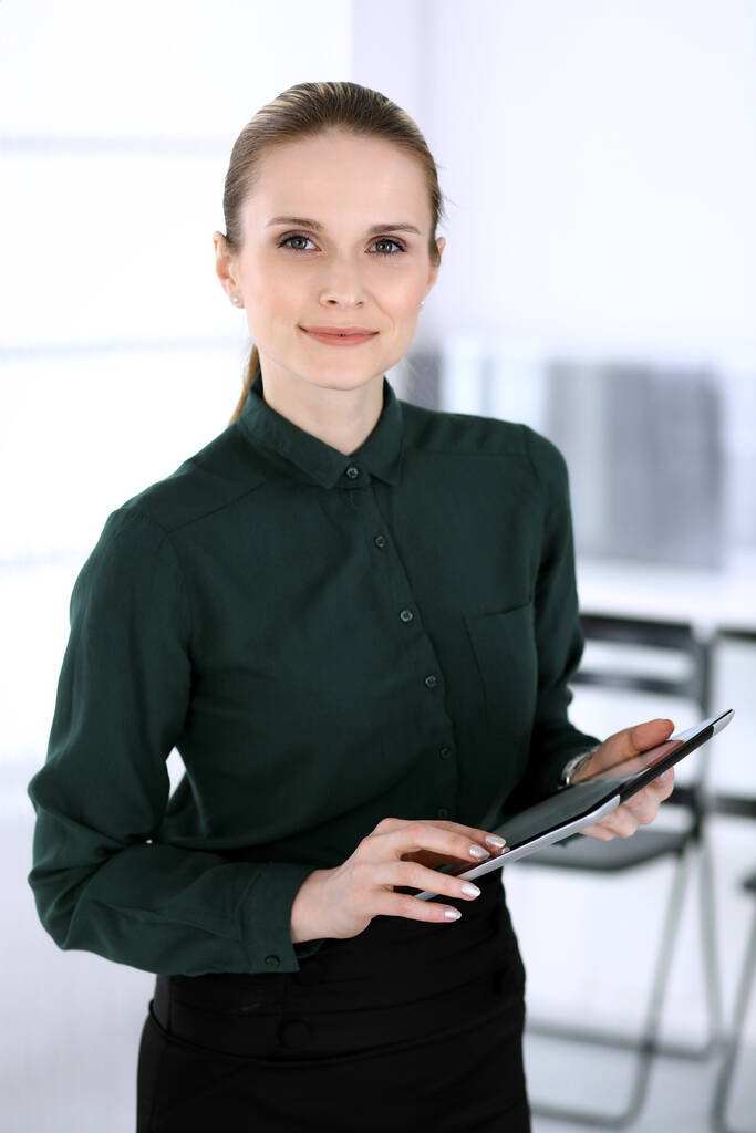 Επιχειρηματίας με φωτογραφία κεφαλής σε μοντέρνο γραφείο. Γραμματέας ή γυναίκα δικηγόρος χρησιμοποιώντας το tablet υπολογιστή, ενώ στέκεται ίσια. Έννοια των επιχειρηματιών - Φωτογραφία, εικόνα