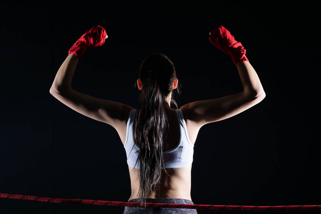 Wojownik MMA wygrał jej pierwszą walkę. Kobieta podniosła ręce na dowód wygranej walki.. - Zdjęcie, obraz